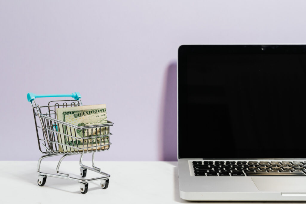 Laptop met een klein winkelwagentje ernaast