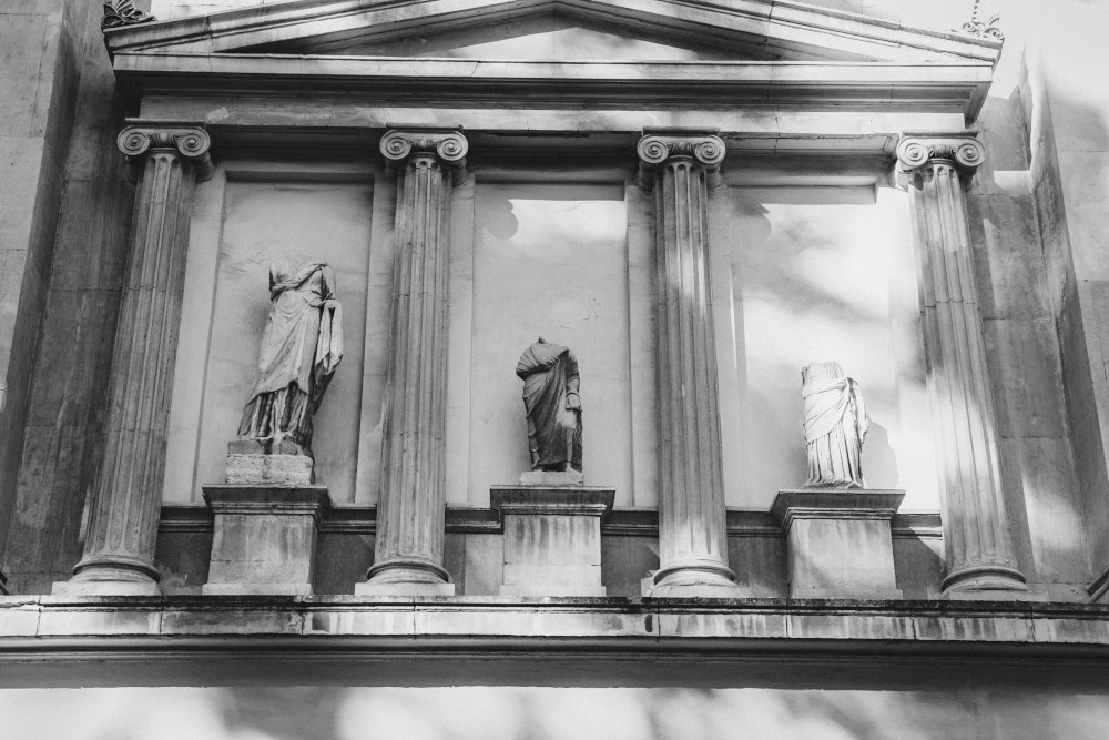 een zwart wit foto van romeinse standbeelden zonder hoofd