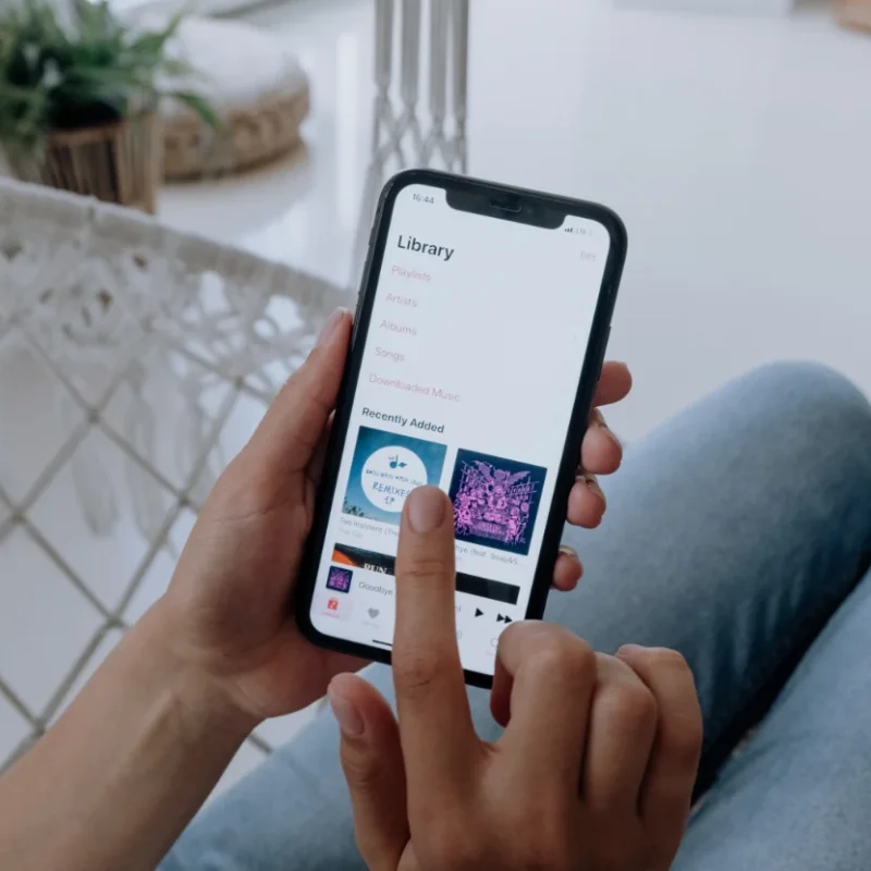 Twee handen houden een telefoon met daarop een app vast