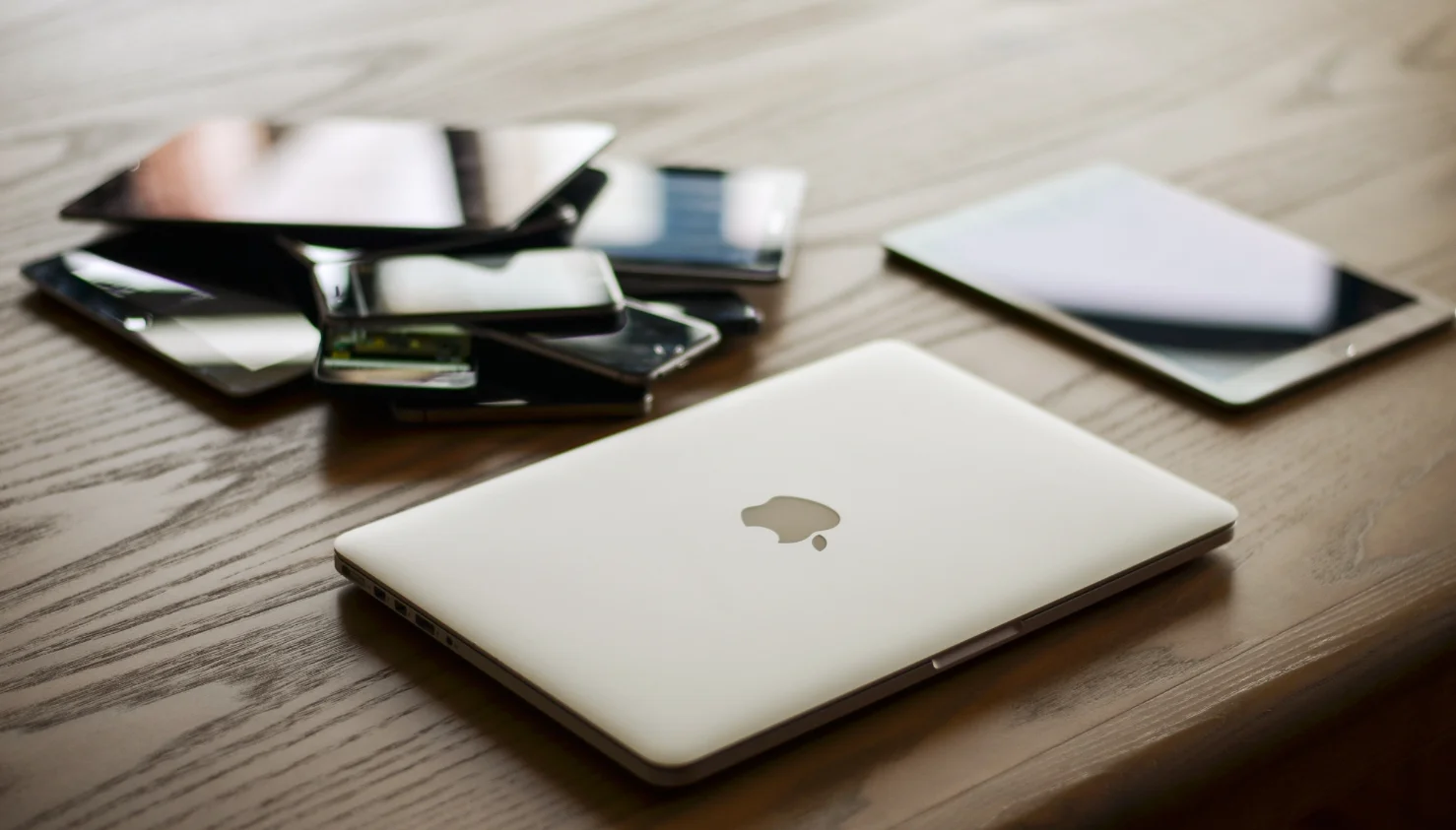 Apple MacBook naast een stapel verschillende telefoons