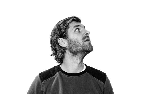 willem guensberg kijkt omhoog tegen een witte achtergrond